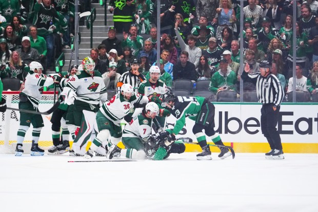 Dallas Stars right wing Mikko Rantanen (96) is dropped to the ice while scuffling with Minnesota Wild players during the second period in Game 1 of a first-round NHL Stanley Cup playoffs hockey series, Saturday, April 18, 2026, in Dallas, Texas. (Julio Cortez)
