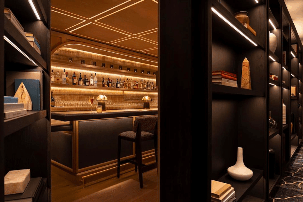 Image shows a bookcase opening up to reveal the hidden Bandista speakeasy inside in Houston.