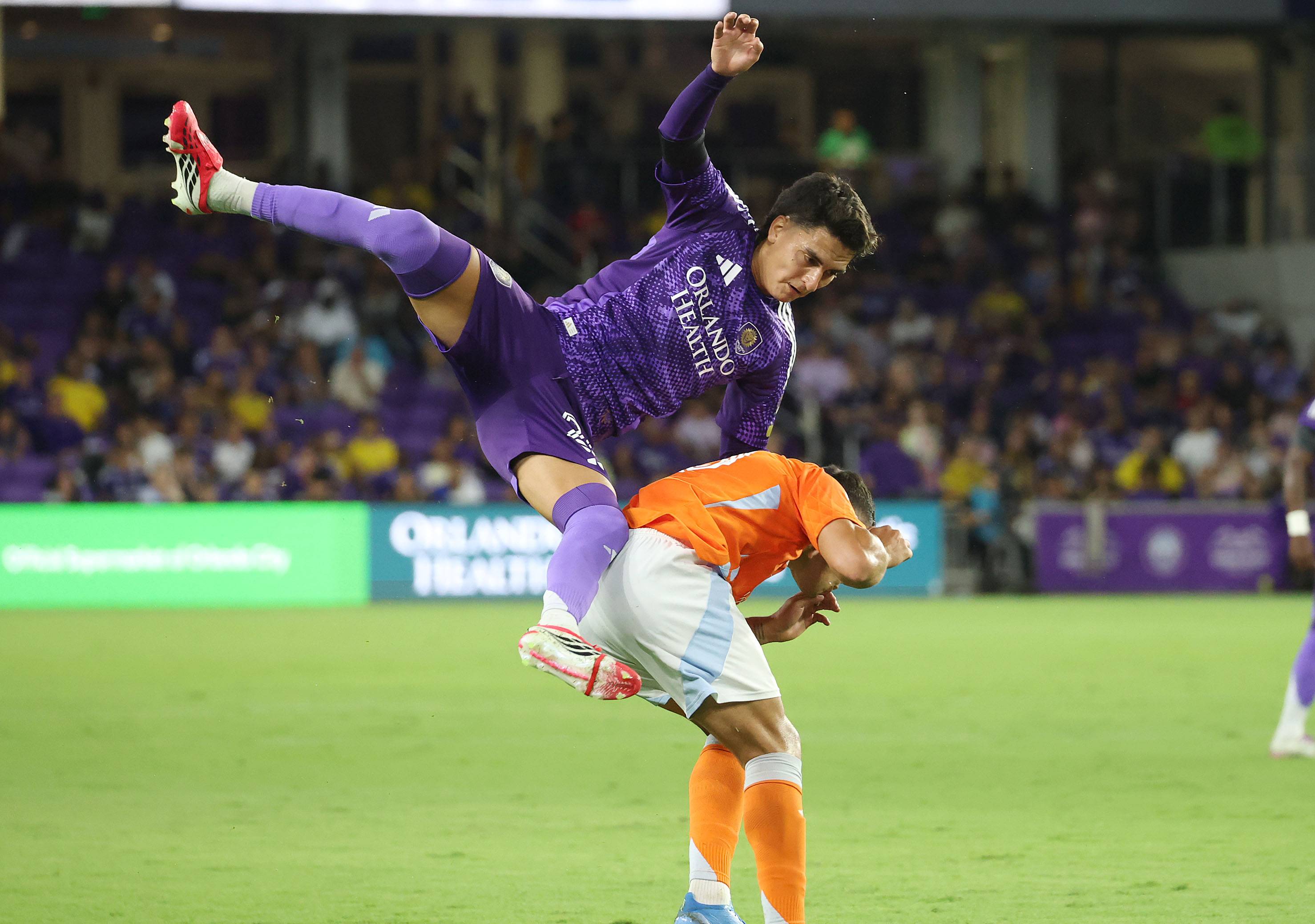 Orlando player Eduard Atuesta (top) leaps over Houston player Ezequiel...