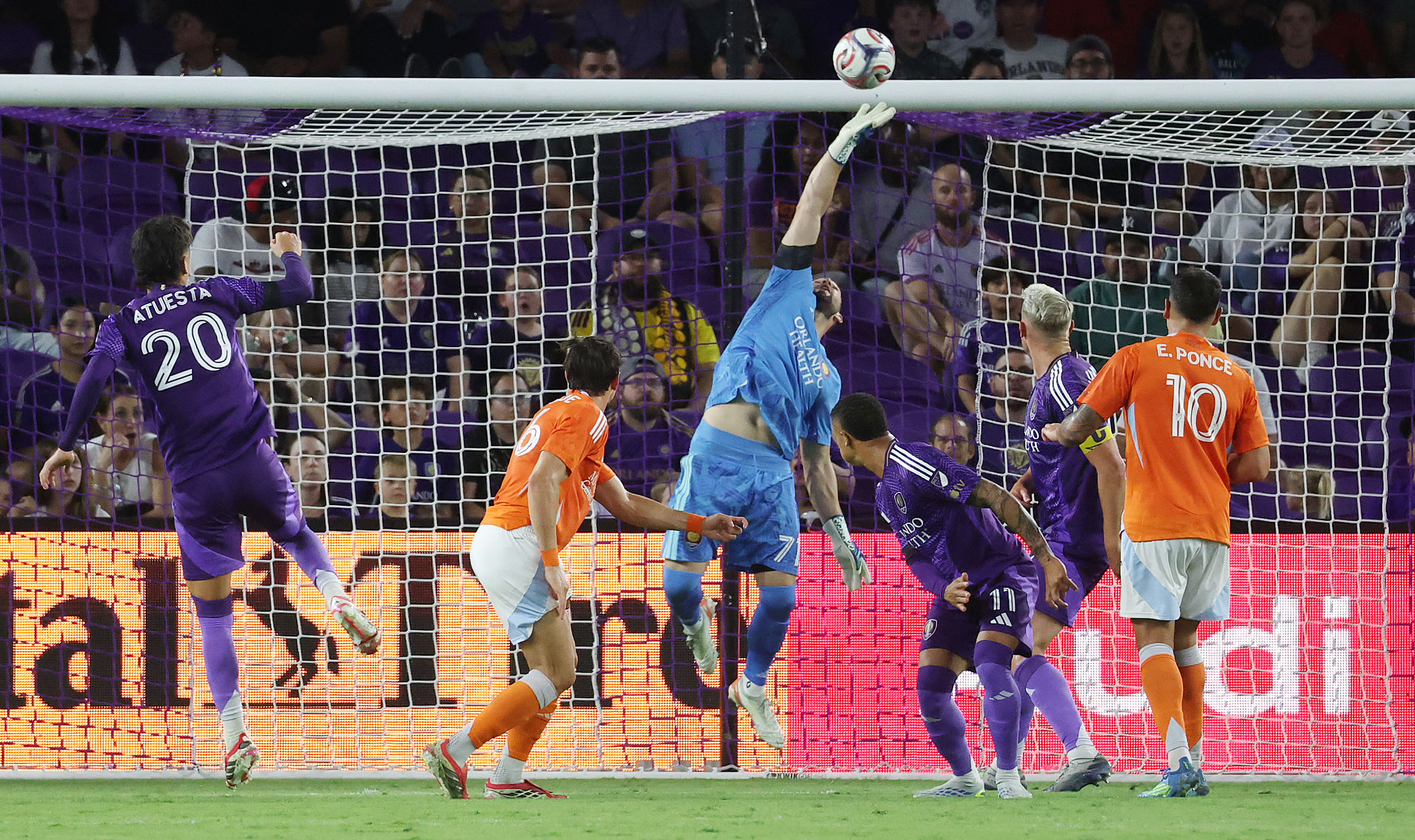 Orlando goalkeeper Maxime Crepeau (middle) leaps to make a save...