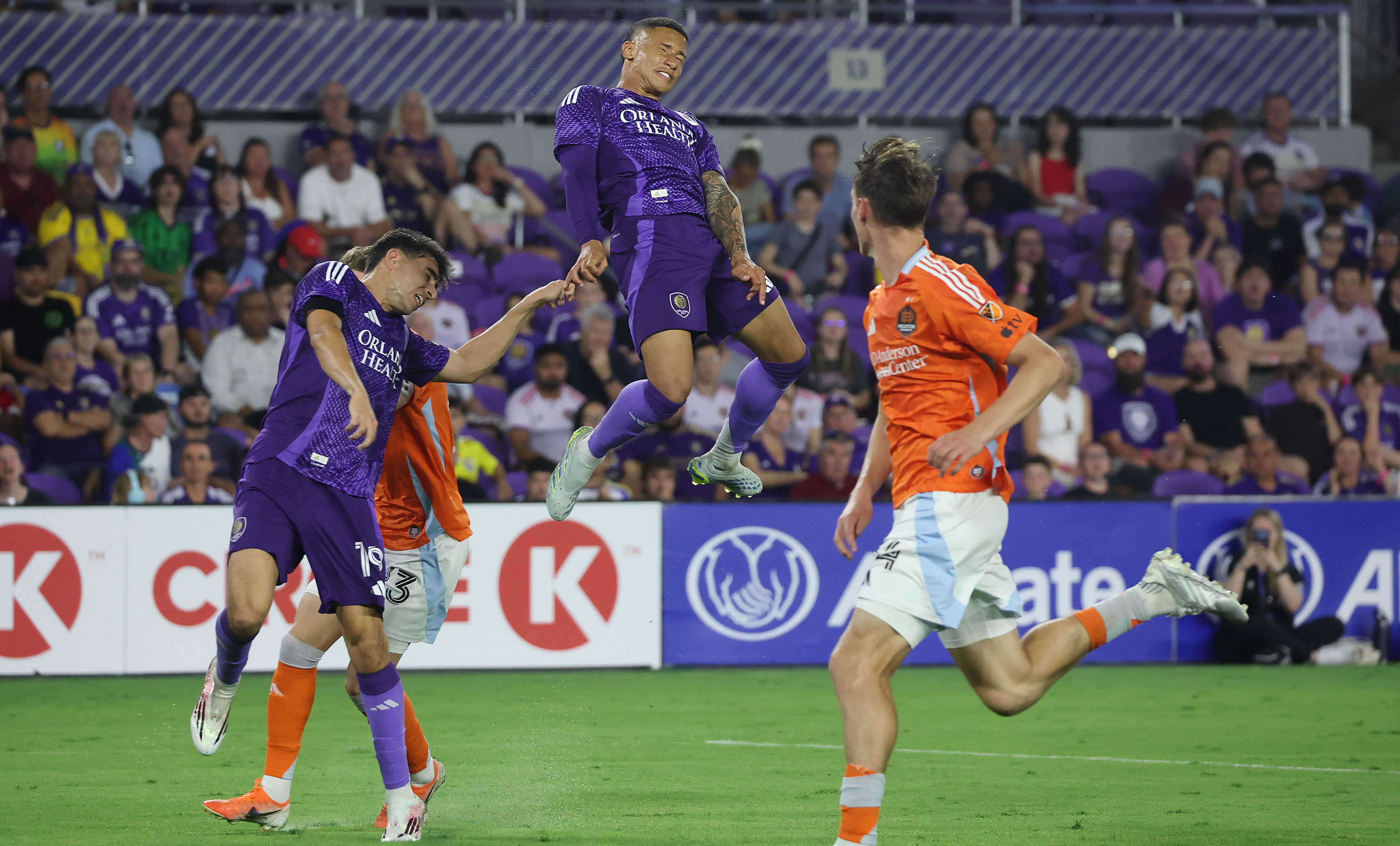 Orlando player Tiago Souza (top) leaps during the Houston Dynamo...