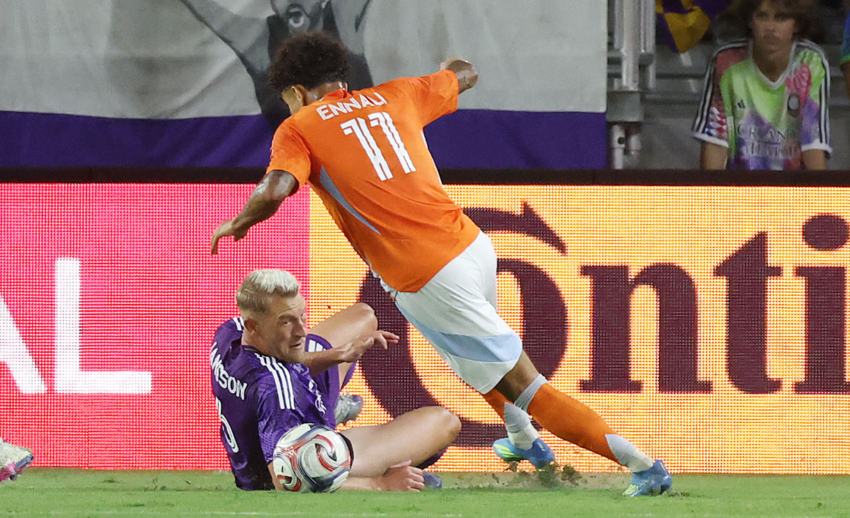 Orlando player Robin Jansson (bottom) slides beneath Houston player Lawrence...