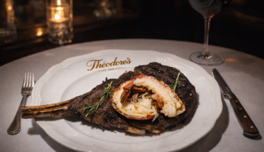 An elegant steak and lobster on a white plate, on a white table cloth.