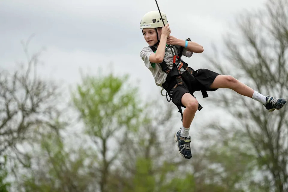 Niko Zuzek swings on a rope swing at Camp For All. Niko jokes that he's afraid of heights, but his friends and family know better. (Aaron E. Martinez/Austin American-Statesman)