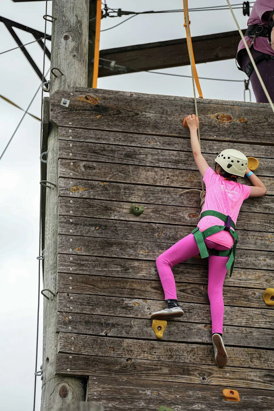 Hazel Bledsoe pulls herself up to the top of the climbing tower at Camp For All. The camp practices "challenge by choice." Each kid gets to decide what they want to do but staff encourages them to push themselves. (Aaron E. Martinez/Austin American-Statesman)