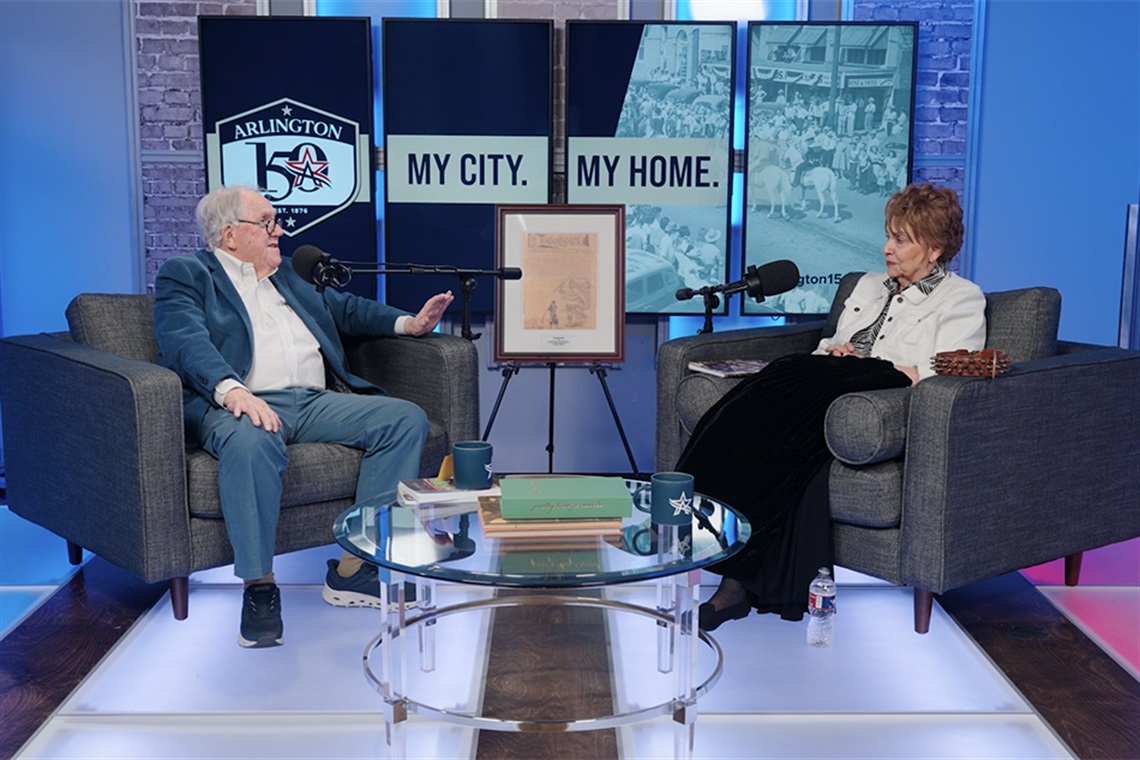 OK Carter sits left and Vickie Bryant sits on the right as they discuss Top O' Hill Terrace with podcast microphones in front of them. 