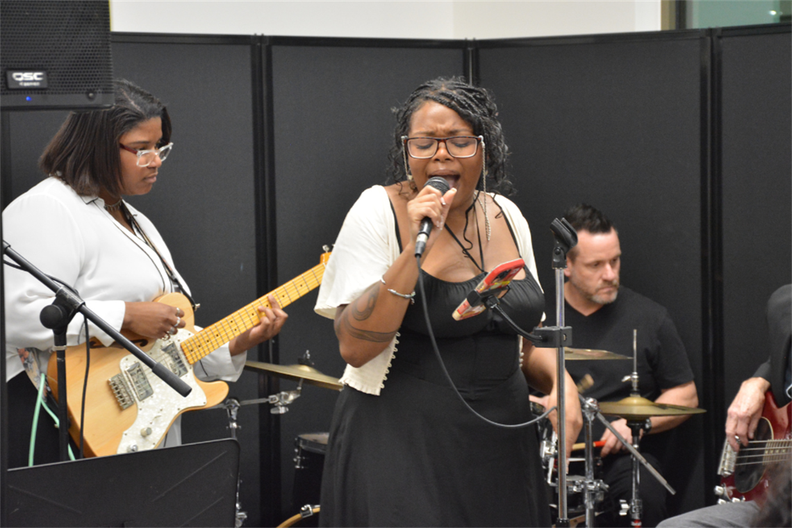 Person with a guitar, another person singing and one more person in the drums.