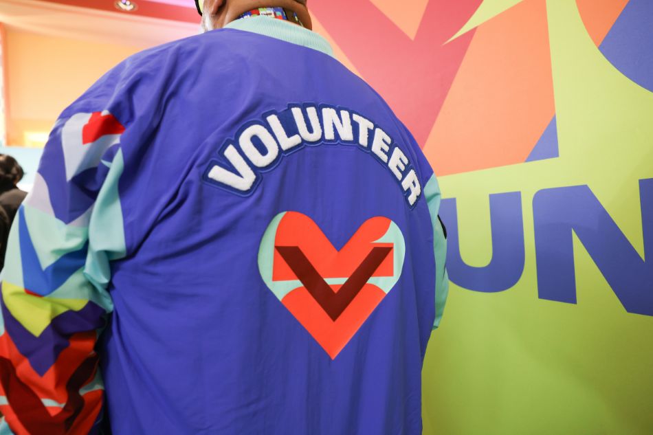 A person wearing a colorful jacket with the word