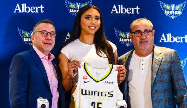 Azzi Fudd holds up her new #35 Dallas Wings jersey alongside General Manager Curt Miller and head coach Jose Fernandez during her introductory press conference in Arlington.