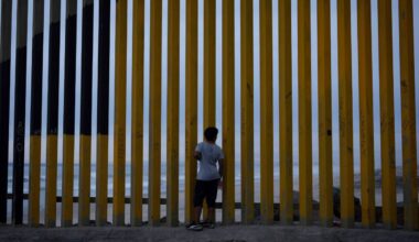 A boy looks through a border wall separating Mexico from the United States, Nov. 26, 2024, in Tijuana, Mexico. (AP Photo/Gregory Bull)