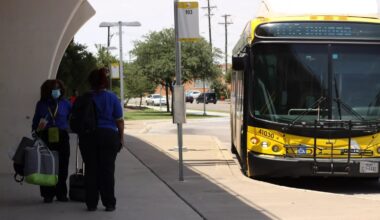 DART bus drivers switch shifts at a bus stop.