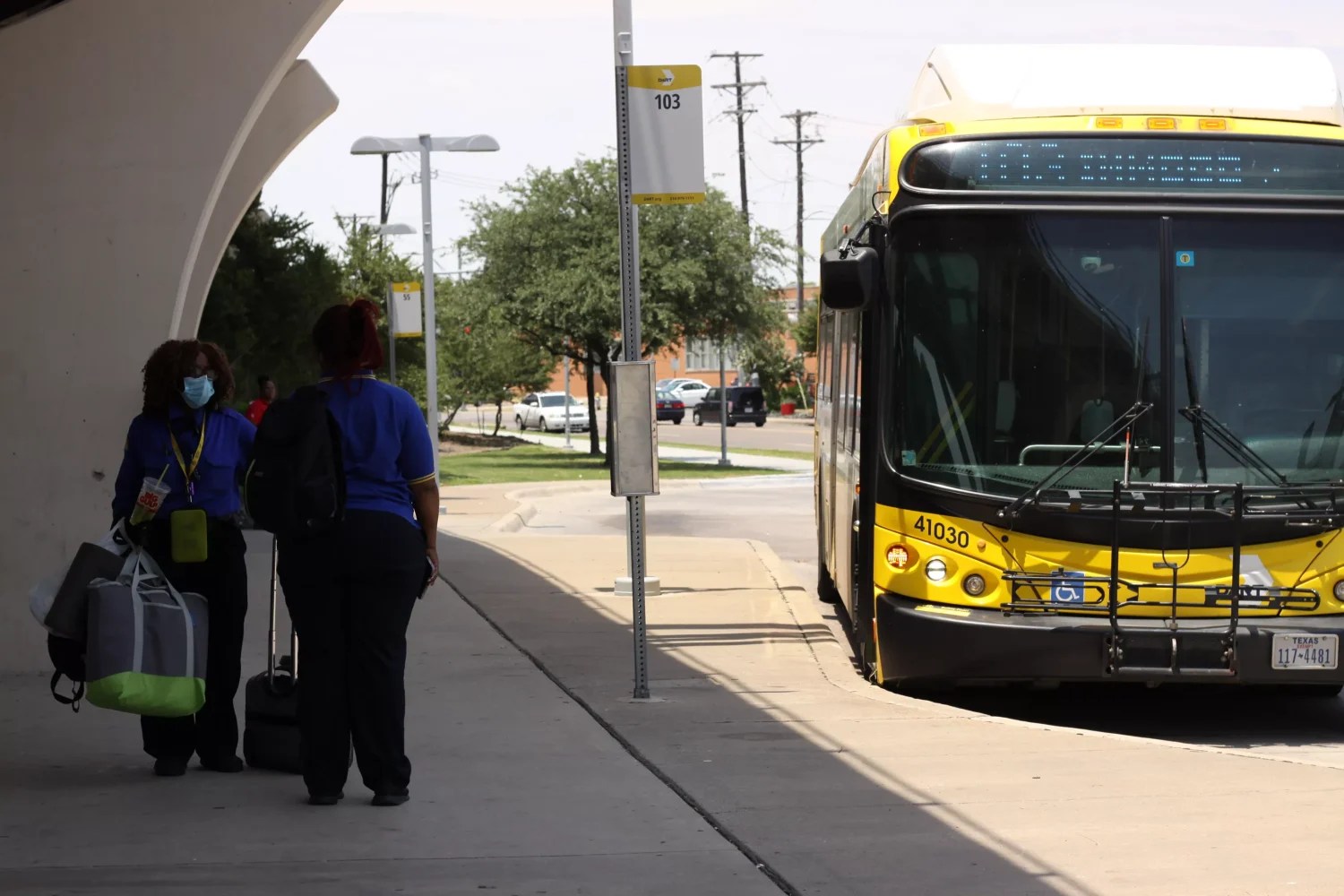 DART bus drivers switch shifts at a bus stop.
