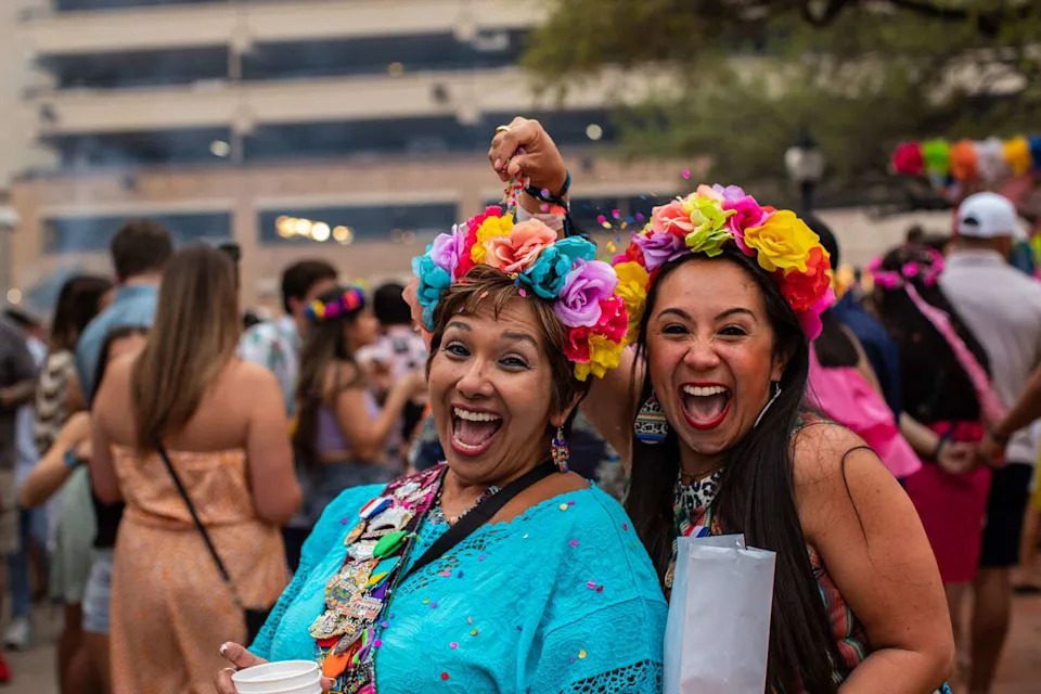 Roxie Chung cracks a cascarones over Sylvia Dimayuga's head for a photograph on the first night of the Fiesta Night in Old San Antonio on 2022. (KAYLEE C GREENLEE BEAL 2022/Kaylee C. Greenlee Beal / San Antonio Express-News file photo)