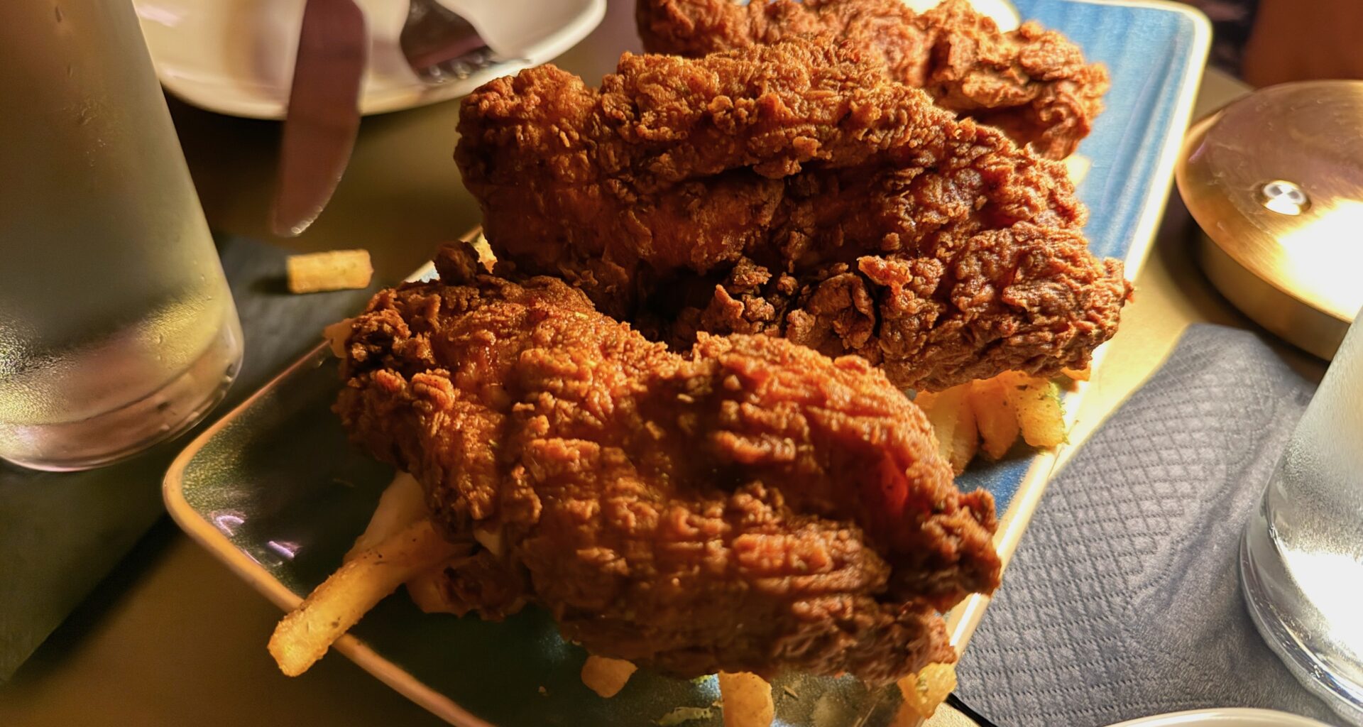 a plate of thick chicken tenders over fries