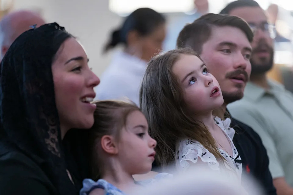 Mason Thompson sits with his wife, Isabella Gonzalez, and their daughters, Sofia and Rose, during Holy Thursday Mass at Most Holy Trinity Catholic Church on April 2, 2026, in El Paso, Texas.