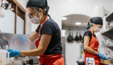 A picture of two people working in the kitchen of a restaurant.