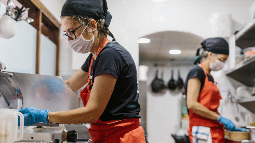 A picture of two people working in the kitchen of a restaurant.
