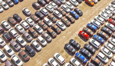 A picture of cars lined up for delivery to consumers.