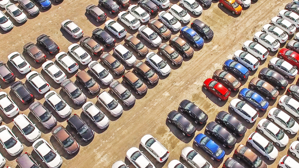 A picture of cars lined up for delivery to consumers.