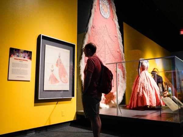 A visitor looks at a gown and train from a Fiesta San Antonio court. | Photo courtesy of the Bullock Texas State History Museum