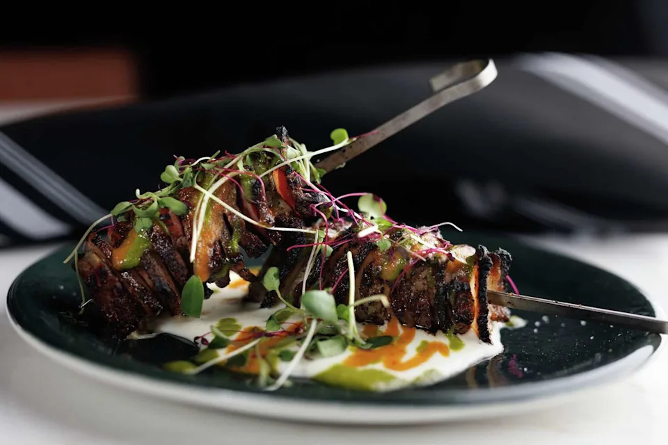 Pig cheek and flake steak skewers ($18) are on Top Brass' dinner menu. Each "flake," or slice of meat, is stacked on a skewer and served with green sauce at the new Addison bistro. (Nathan Hunsinger/The Dallas Morning News)