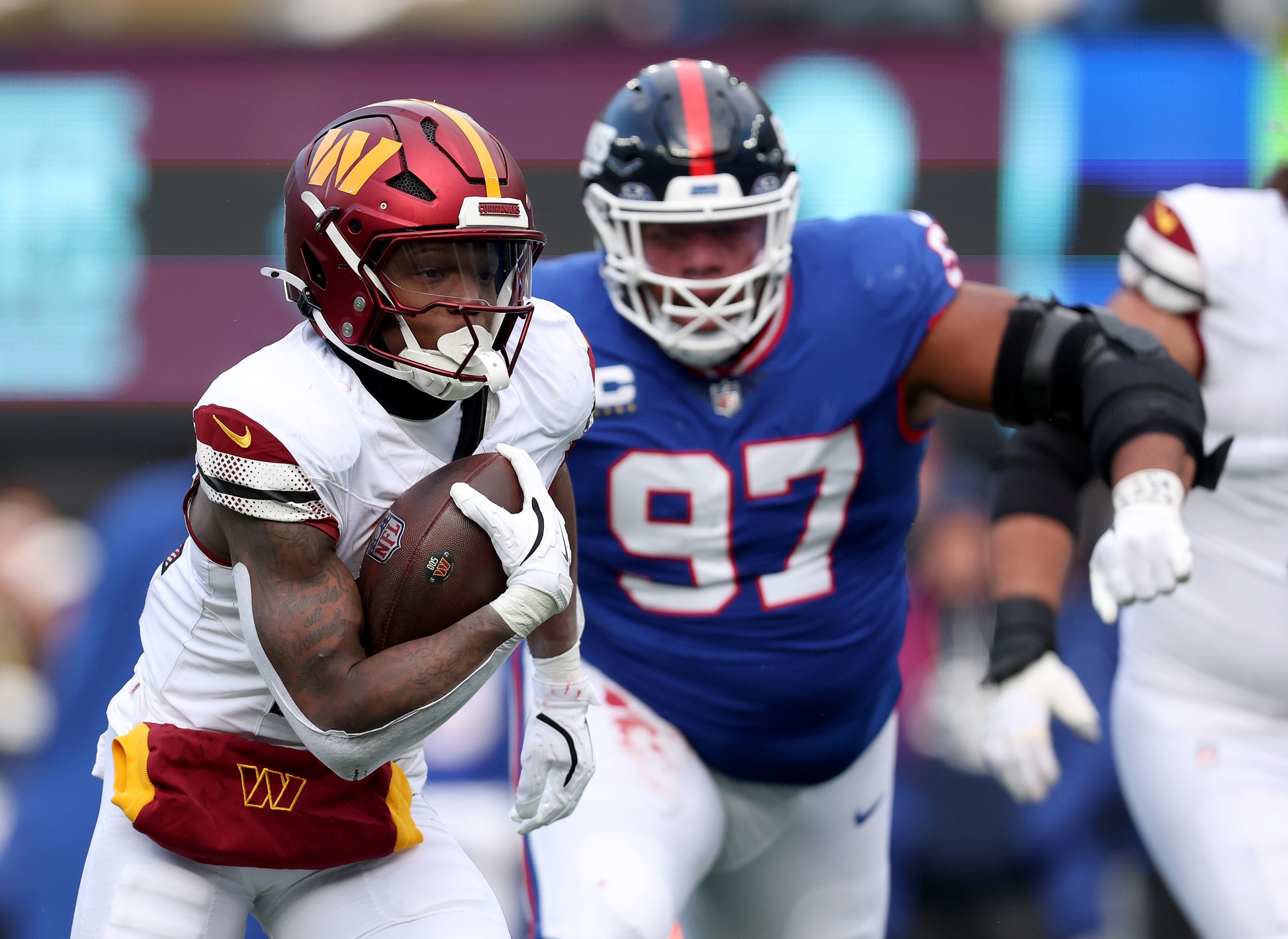 EAST RUTHERFORD, NEW JERSEY - DECEMBER 14: Jacory Croskey-Merritt #22 of the Washington Commanders runs the ball in for a touchdown as Dexter Lawrence II #97 of the New York Giants defends at MetLife Stadium on December 14, 2025 in East Rutherford, New Jersey. (Photo by Elsa/Getty Images)