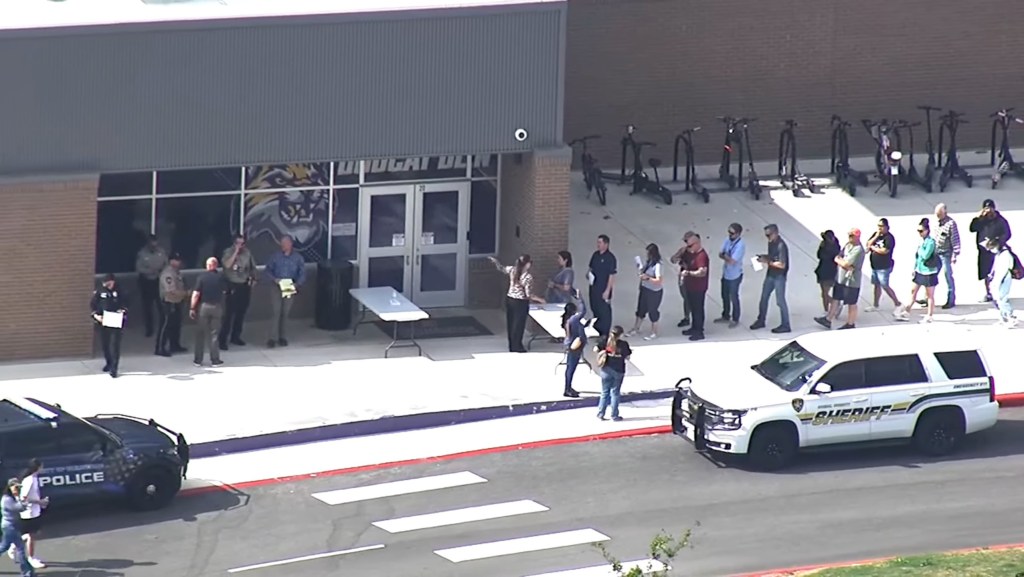 Police and sheriff's vehicles and personnel outside Hill Country College Preparatory High School.