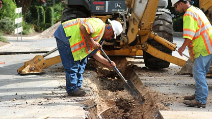 Austin Water workers excavating an underground water pipe.