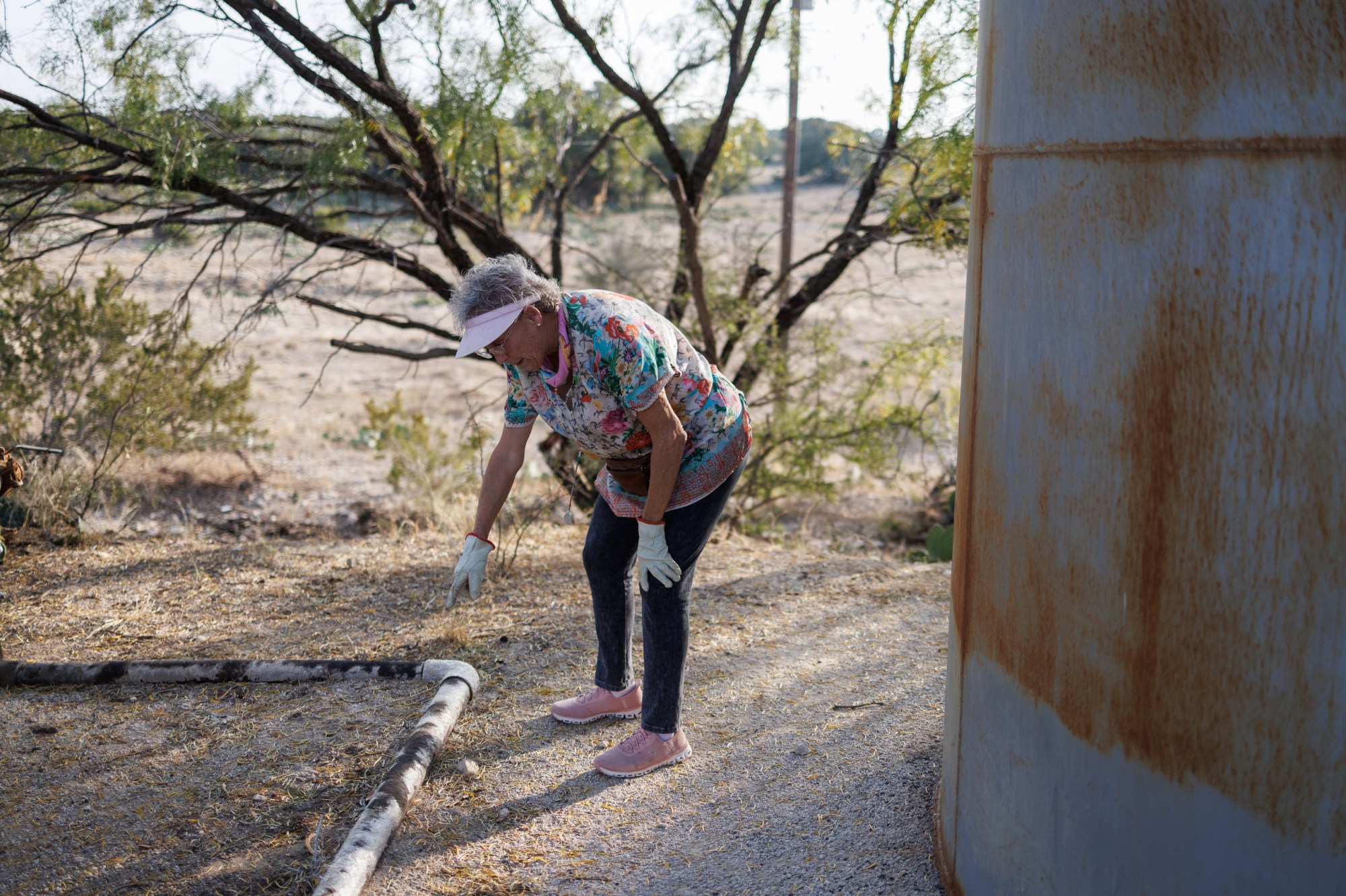 Jackie Lynn Chestnutt points to a leaky oil pipe next to a tank battery owned by Core Petro LLC which is in disrepair on her property in Knickerbocker, Texas on Tuesday, November 18, 2025. A large number of orphan oil wells are dotted around her large property, causing worry that ground water could be contaminated by leeching oil, produced water or chemicals.