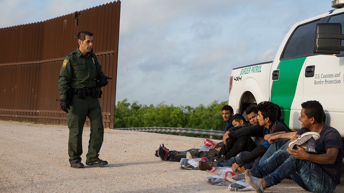 Border Patrol agent apprehending immigrants near McAllen Texas
