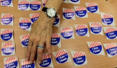 An election judge arranges "I Vote, I Count" stickers on a table in the Marion County Clerks office as voters cast early ballots in Indianapolis, Oct. 22, 2012. (AP Photo/Michael Conroy)