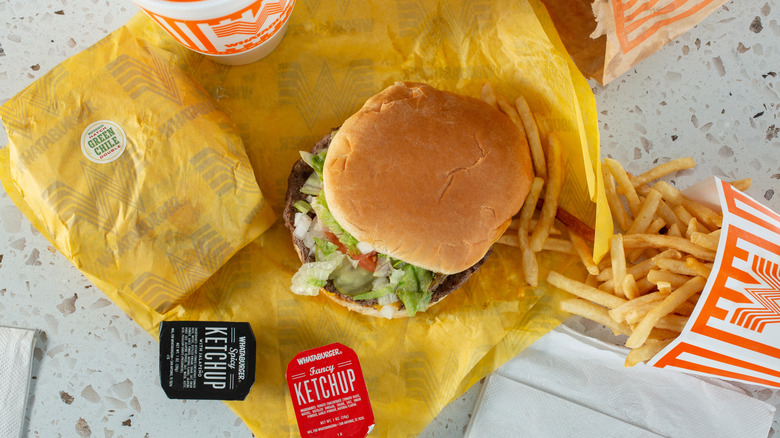 Whataburger meal with burger, fries, drink, and sauces.