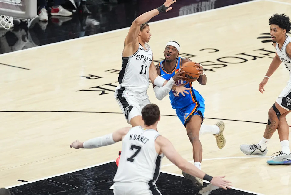May 24, 2026; San Antonio, Texas, USA; Oklahoma City Thunder guard Shai Gilgeous-Alexander (2) drives the ball while defended by San Antonio Spurs forward Carter Bryant (11) in the third quarter during game four of the western conference finals for the 2026 NBA playoffs at Frost Bank Center. Mandatory Credit: Daniel Dunn-Imagn Images