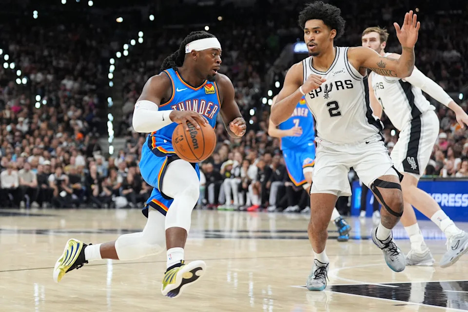 May 24, 2026; San Antonio, Texas, USA; Oklahoma City Thunder forward Luguentz Dort (5) drives the ball while defended by San Antonio Spurs guard Dylan Harper (2) in the fourth quarter during game four of the western conference finals for the 2026 NBA playoffs at Frost Bank Center. Mandatory Credit: Daniel Dunn-Imagn Images