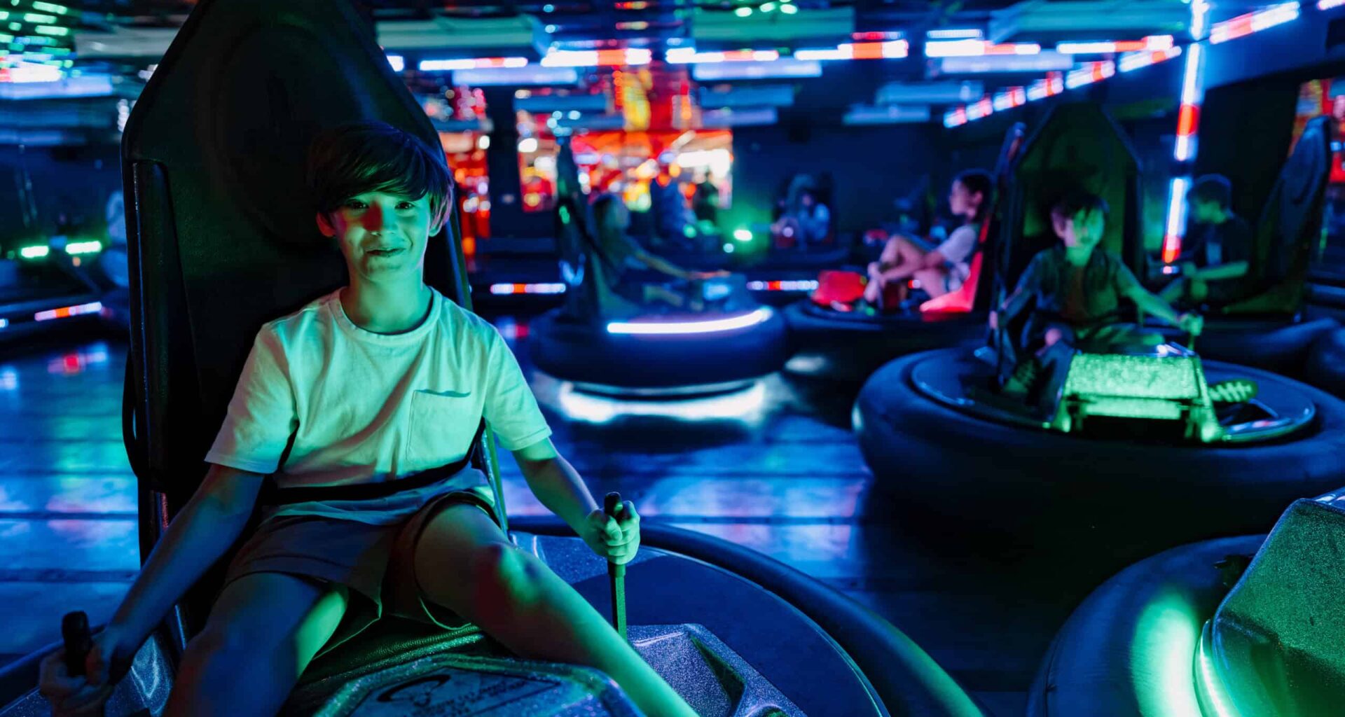 Child enjoying arcade bumper car ride at Pinstack amusement center