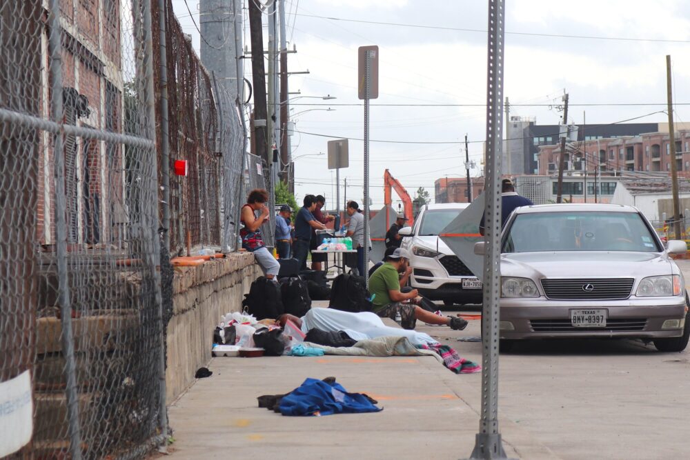Homeless people wait in line for meals provided by a church group in East Downtown.