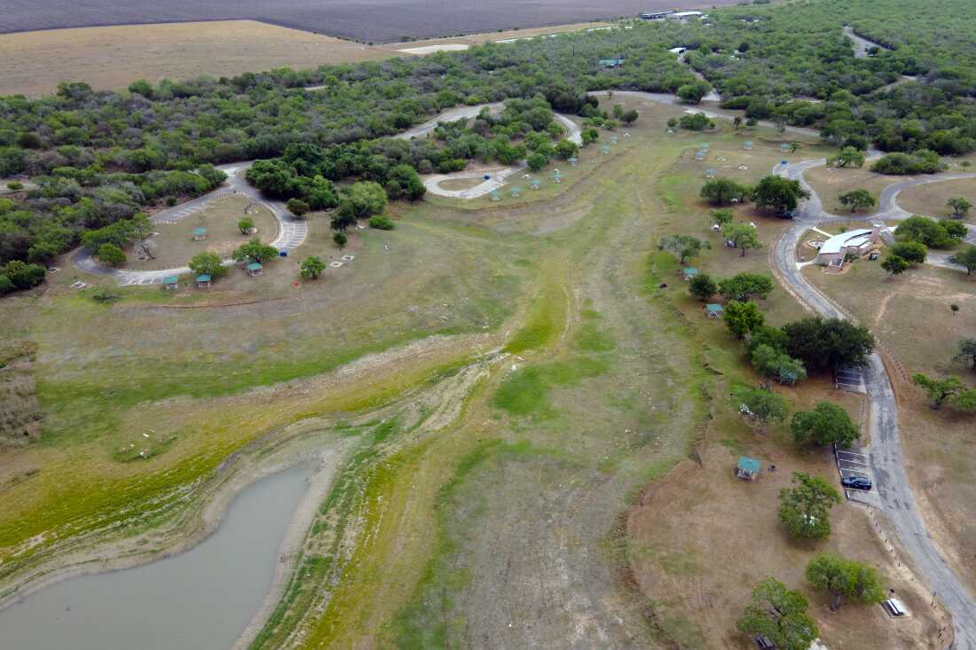 A top-down aerial view of Lake Corpus Christi reveals dry lakebed and shrinking water levels as drought continues to strain the region’s supply on April 10, 2026.