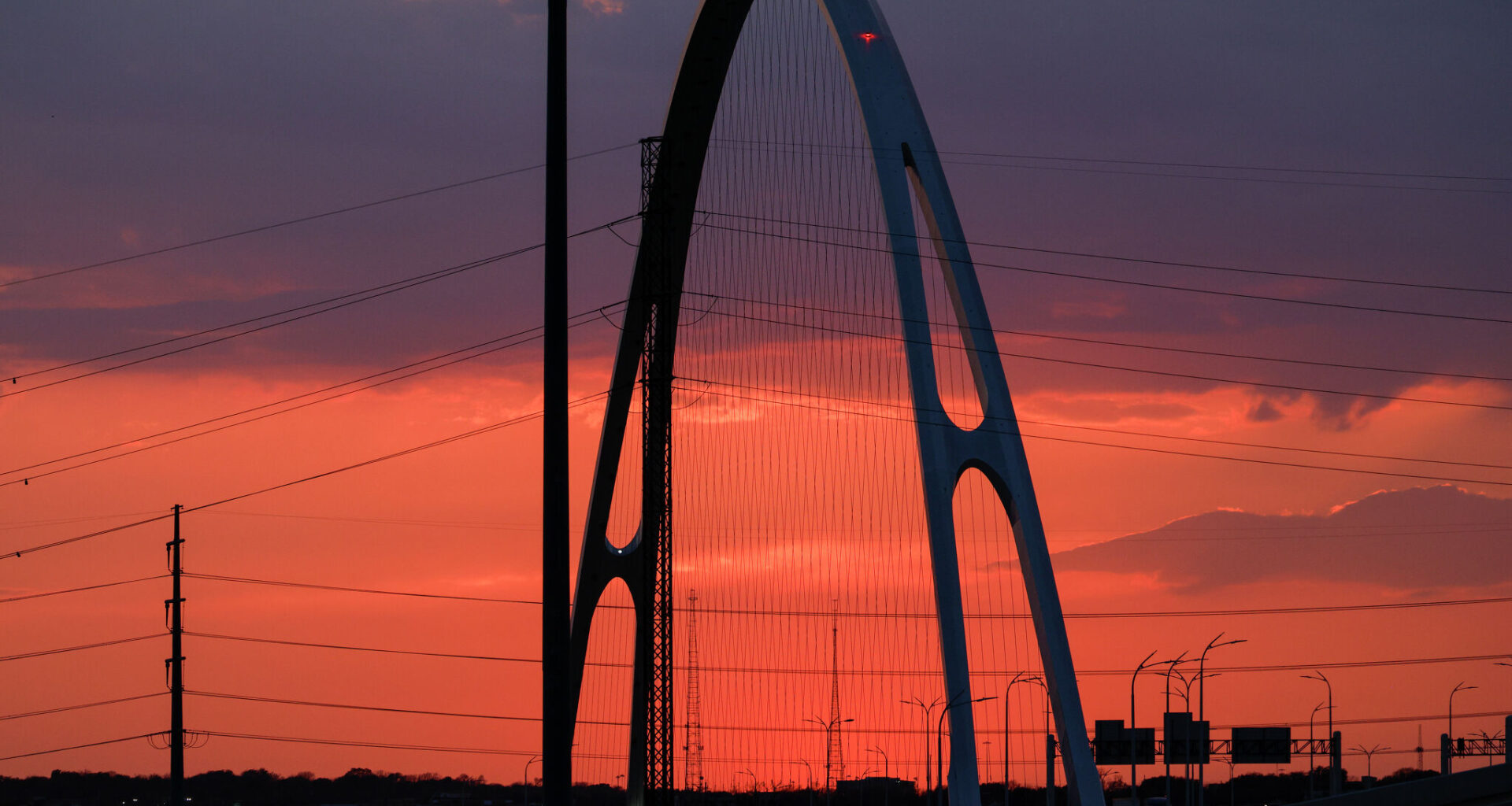 The sun sets behind Interstate 30 and Oak Cliff, Friday, March 6, 2026, in Dallas.
