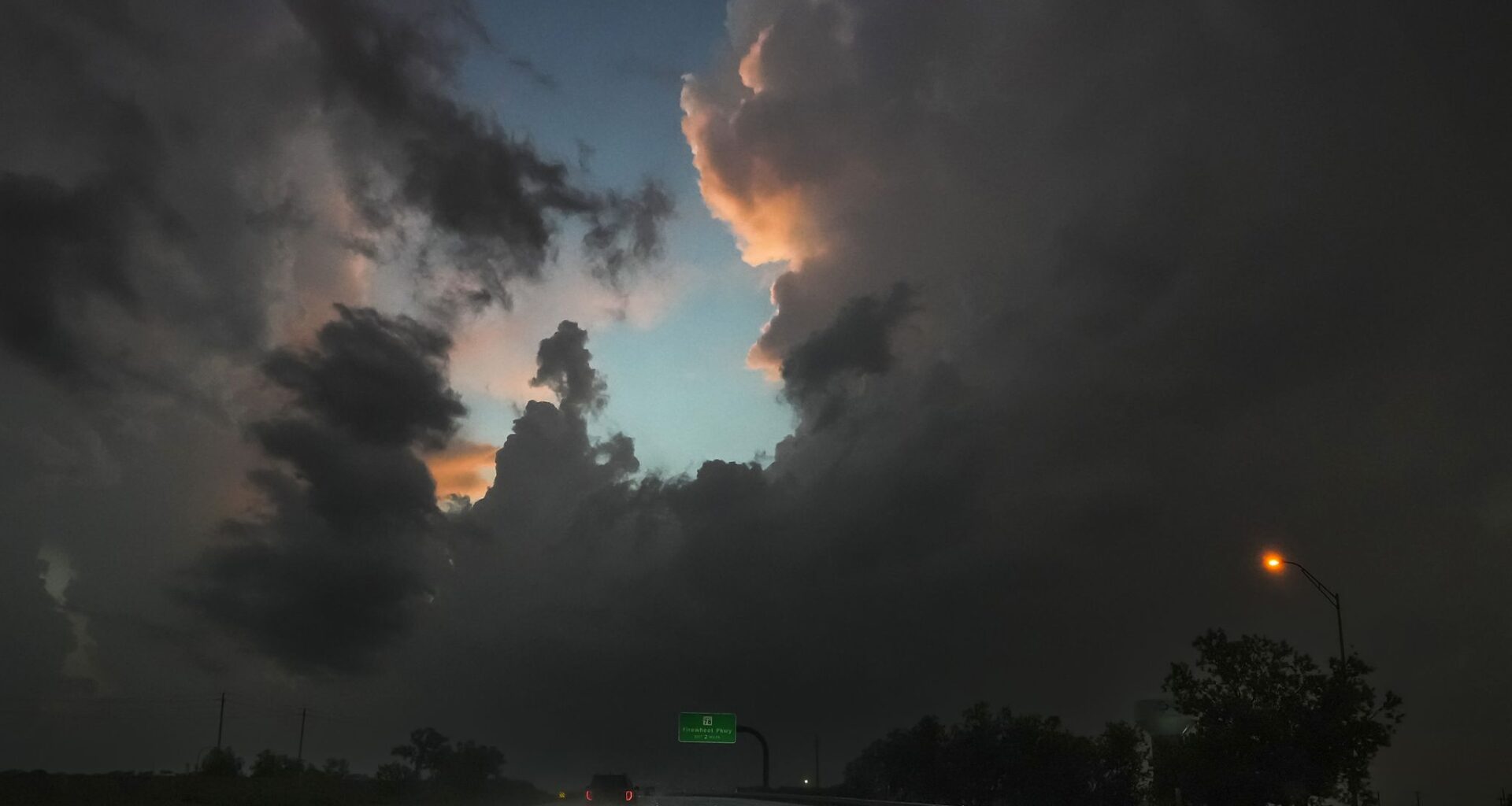 Storm clouds loom over traffic on President George Bush Turnpike in Sachse, Monday, April 27, 2026.