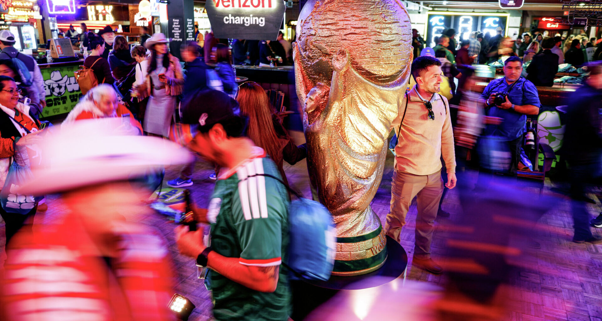 Fort Worth resident Federico Robles, 34, takes a photo with the World Cup trophy statue during the draw watch party on Friday, Dec. 5, 2025, in Fort Worth.