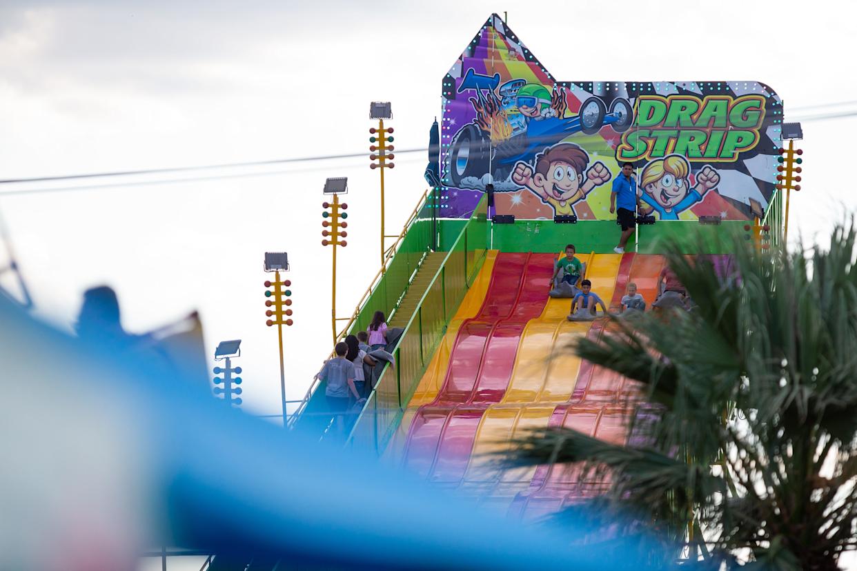 People slide down the Drag Strip attraction at the annual Buc Days Carnival in downtown Corpus Christi on May 9, 2025.