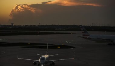 American Airlines planes taxi toward Terminal B at DFW Airport as storm clouds are seen on the horizon on Friday, April 24, 2026.