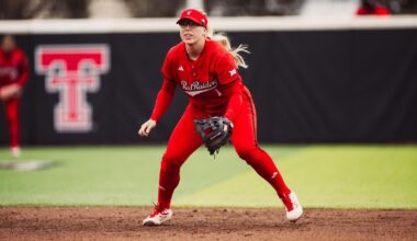 Texas Tech softball team celebrating winning the Big 12 by taking a team picture infornt of the trophy at Tracy Sellers Field