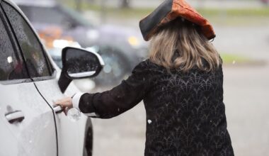 A woman runs to a car as heavy rain and hail fall in Rowlett, Monday, April 27, 2026.