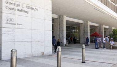 People stand outside the George Allen Courts Building after a water leak, Tuesday, July 2, 2024, in Dallas.