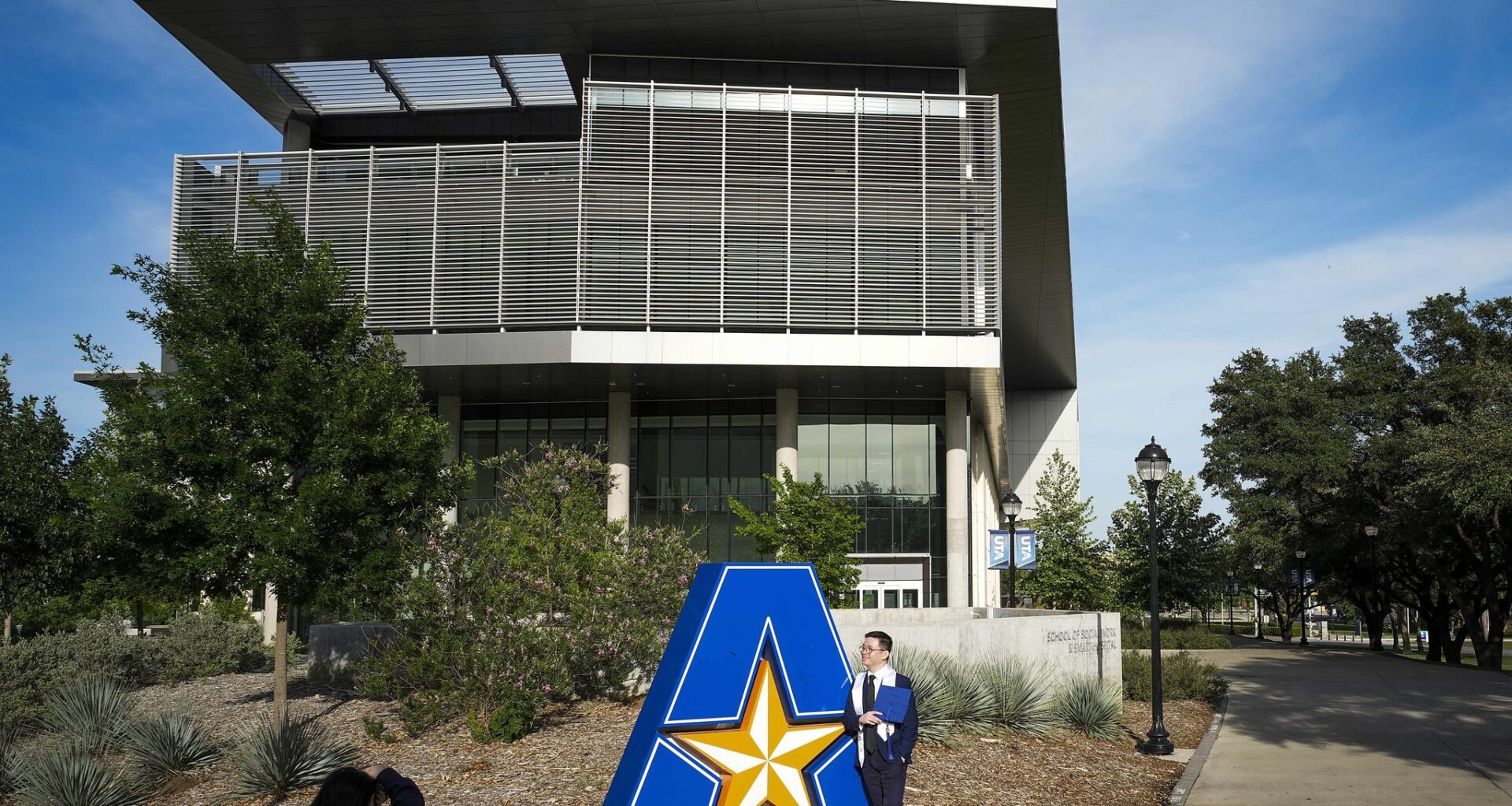 Students pose for photos on the campus of the University of Texas at Arlington on April 19, 2026.