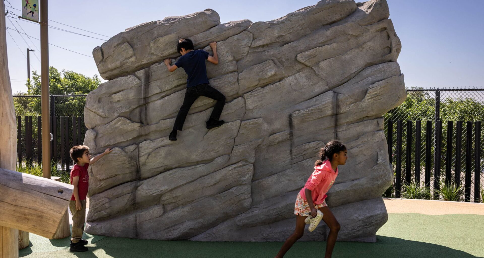 Esperanza Chambers runs off while Noah Gutierrez, 5, watches brother Nicolas Gutierrez, 9, climb a wall at Halperin Park during the opening celebration of Oak Cliff’s new deck park in Dallas, Saturday, May 9, 2026.