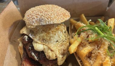 A spicy brisket burger with eggs and two thick strips of brisket, and a side of truffle fries at Black Board Bar B Q in Sisterdale, Texas.  