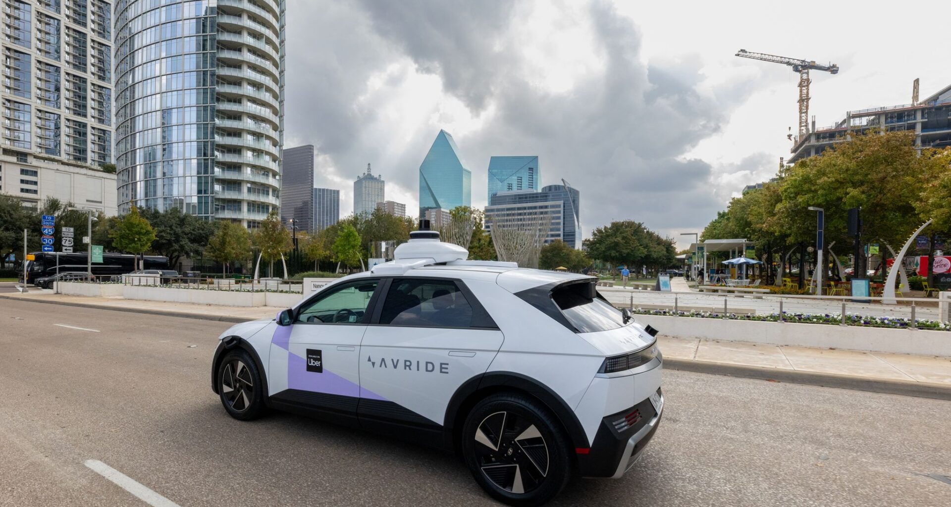 An Avride autonomous vehicle, part of Uber's robotaxi fleet, is pictured driving by Klyde Warren Park in Downtown Dallas. On Dec. 3, 2025, Uber launched autonomous robotaxi rides in Dallas through Avride.