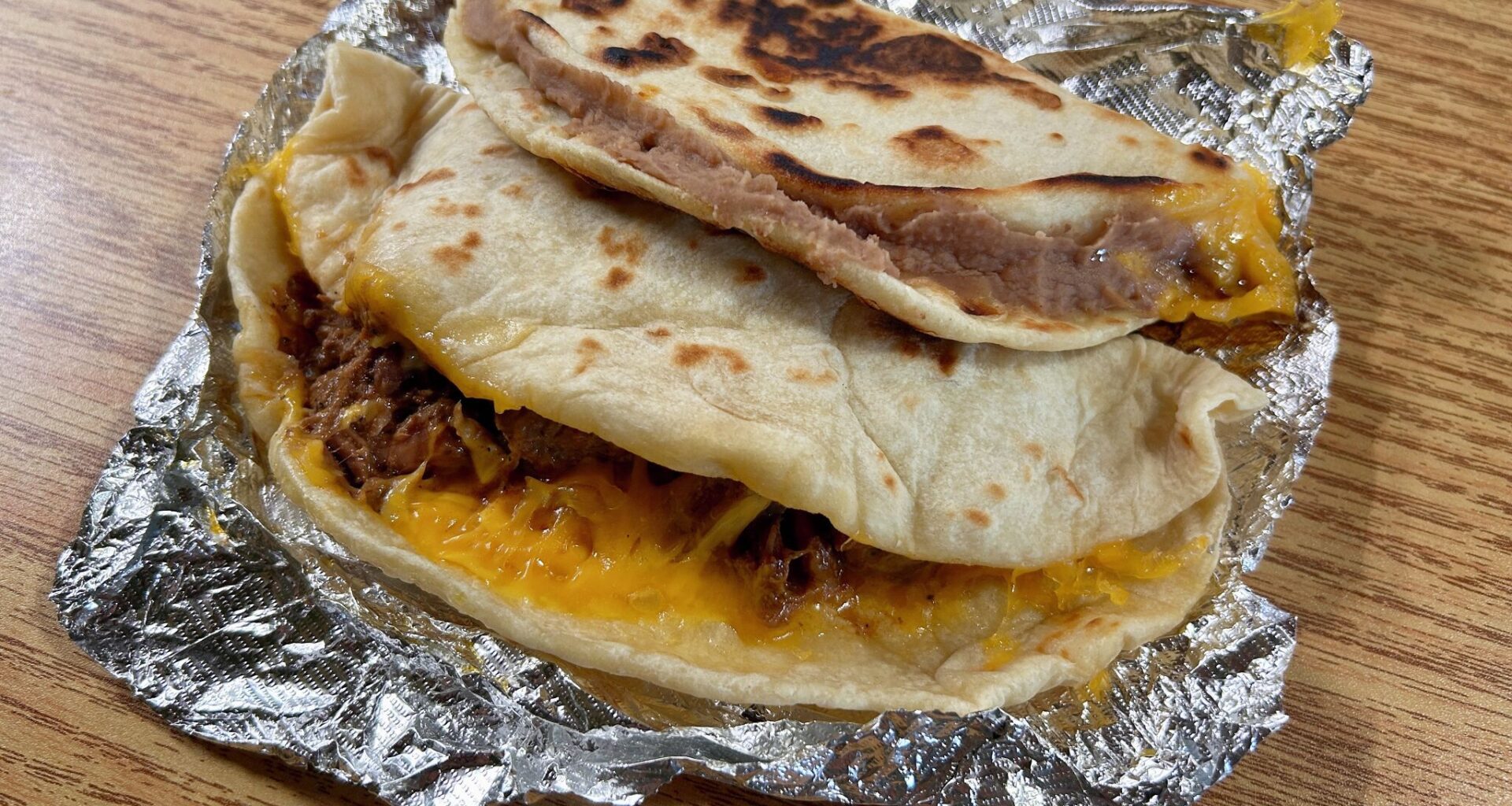 Toasted bean and cheese with bacon and carne guisada tacos from Original Donut Shop.